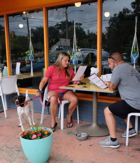 two customers and their dog enjoying dashi patio